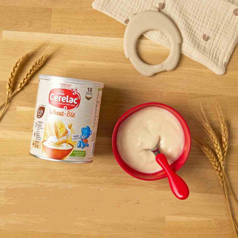Prepared Cerelac baby cereal in a bowl with feeding spoon and baby bib