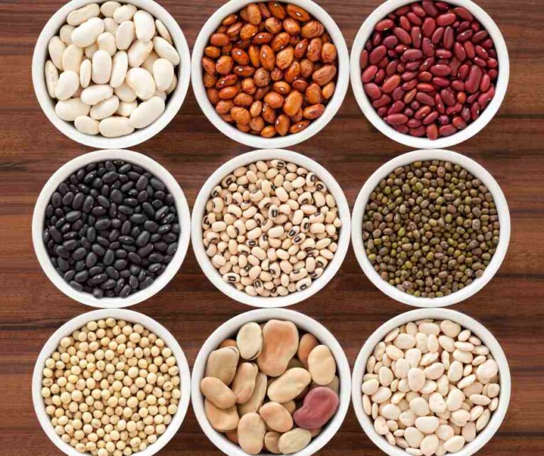 Assorted dried beans including honey beans, kidney beans, black-eyed beans and lentils displayed in bowls on a kitchen counter in a UK home.